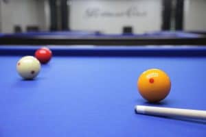 a photo of a 3-cushion table with cue ball yellow and red ball