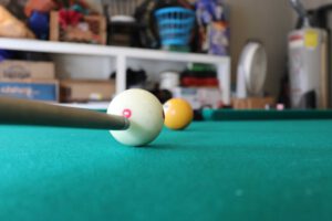 close up of the tip of the cue lined up just beneath the center of the cue ball