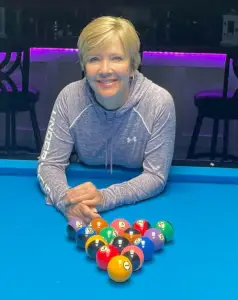 Photo of Allison Fisher leaning on a pool table
